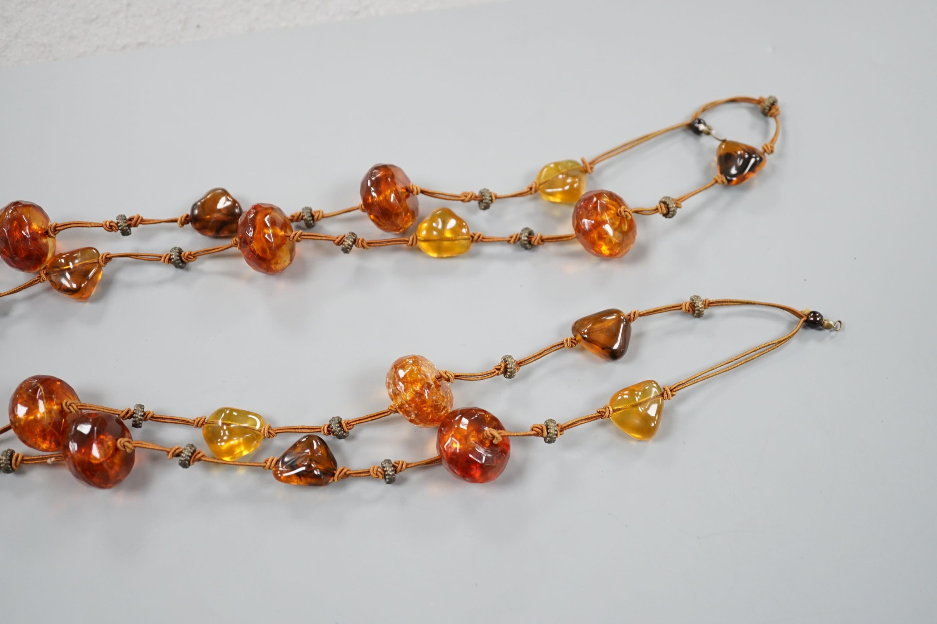 A single strand facetted and pebble amber necklace, 138cm.